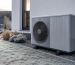 Air source heat pump outdoor unit in a European home garden with light frost on the outdoor coil
