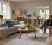 Two people in an ordinary European living room showing room size and occupancy context